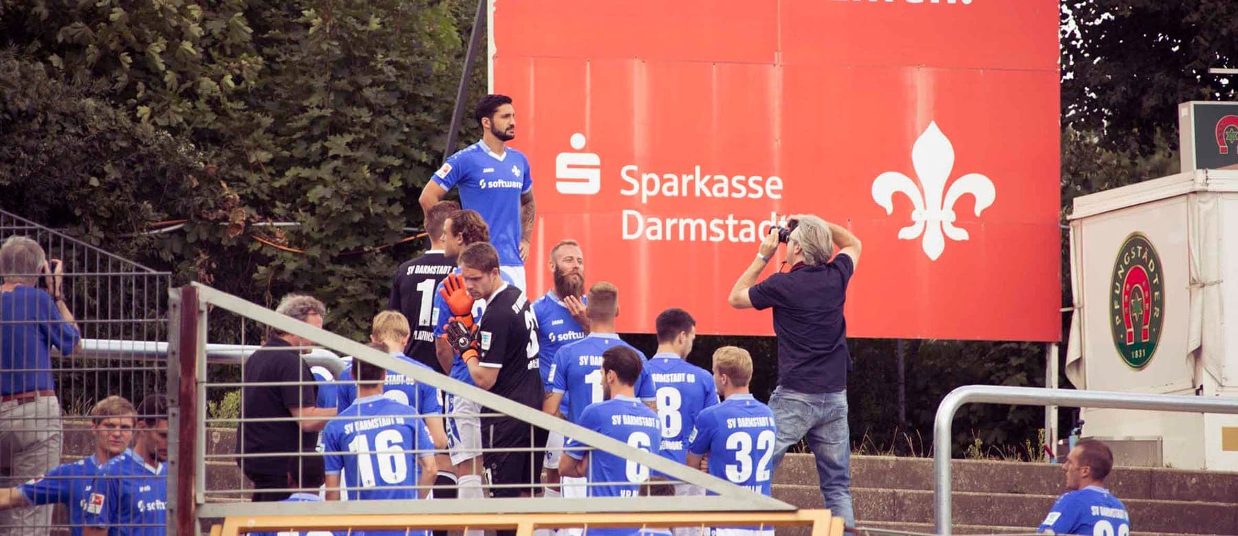 Fototermin am Stadion: Spieler auf der Tribünentreppe, davor Fotografen