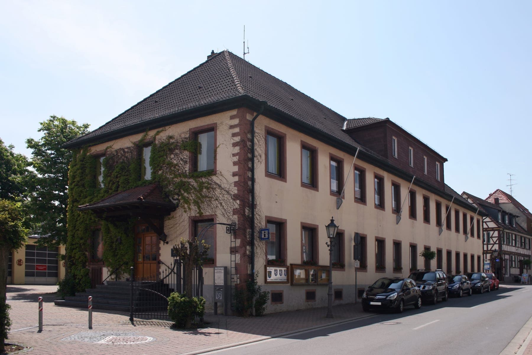 Das Rathaus von Fränkisch-Crumbach: ein langgestrecktes Steingebäude mit Walmdach an der Dorfstraße